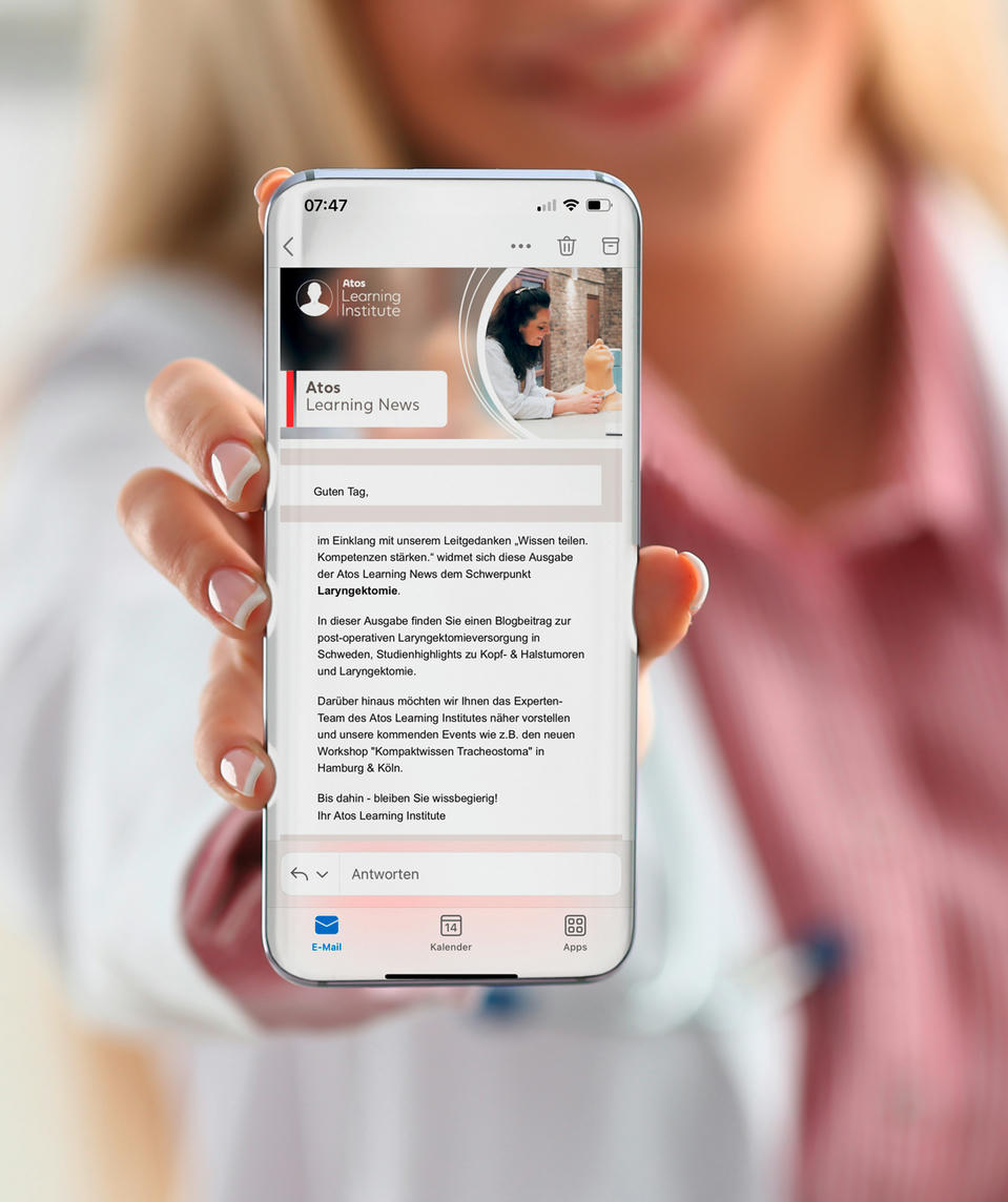 Atos Medical – Ärztin zeigt den Atos Learnin News Newsletter aud ihrem Handy.
