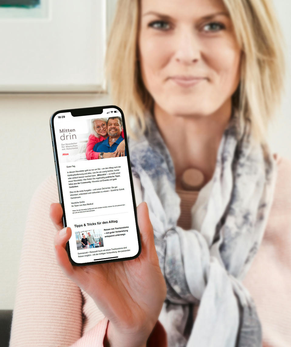 Atos Medical - Frau mit einem Halsstoma liest den Newsletter auf dem Handy
