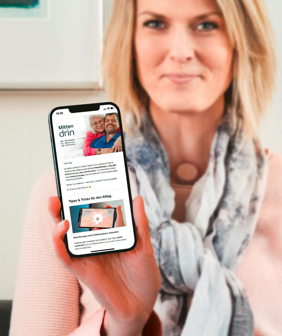 atos-medical-pat-newsletter-1750x1000_n Atos Medical - Frau mit einem Halsstoma liest den Newsletter auf dem Handy